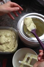 Eine Person löffelt selbstgemachtes Eis aus einer Eismaschine.
