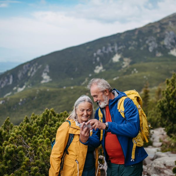Zwei Personen in Wanderkleidung stehen in einer abgelegenen Berglandschaft.
